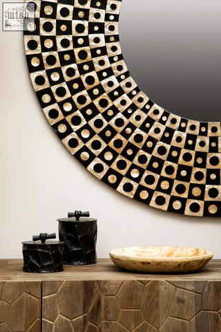 Circular mirror with black and cream geometric frame shown beside the akola large black and gold trinket box