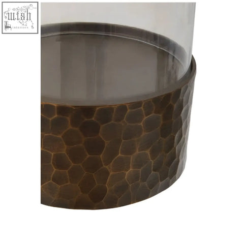 A hammered bronze small antique gold candle holder with a clear glass top perfect for cozy decor