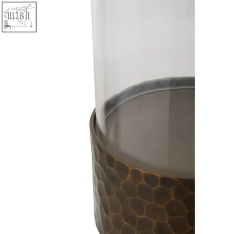 Akola small antique gold candle holder with a tall clear glass cylinder and hammered bronze base with silver rim