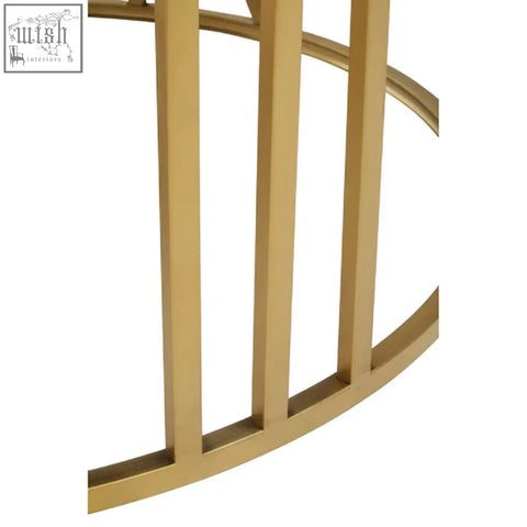 Gold-toned metal round coffee table with curved vertical slats and black glass top in a modern geometric design
