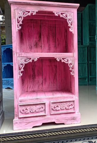 A distressed pinkwash albasia bathroom cabinet with ornate carved details and two drawers at the base
