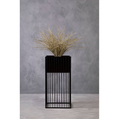 Black metal alden floor standing planter with vertical slats holding dried golden grass for stylish decor