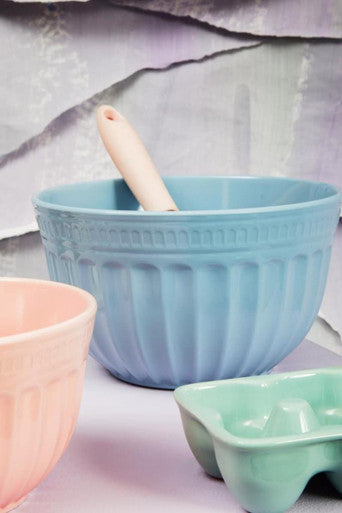 A pastel blue ribbed alden melamine extra large mixing bowl with a wooden-handled spatula inside