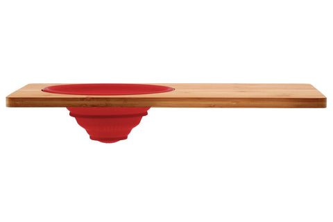 Red silicone bowl nestled in aleki bamboo chopping board with silicone colander bamboo chopping shelf