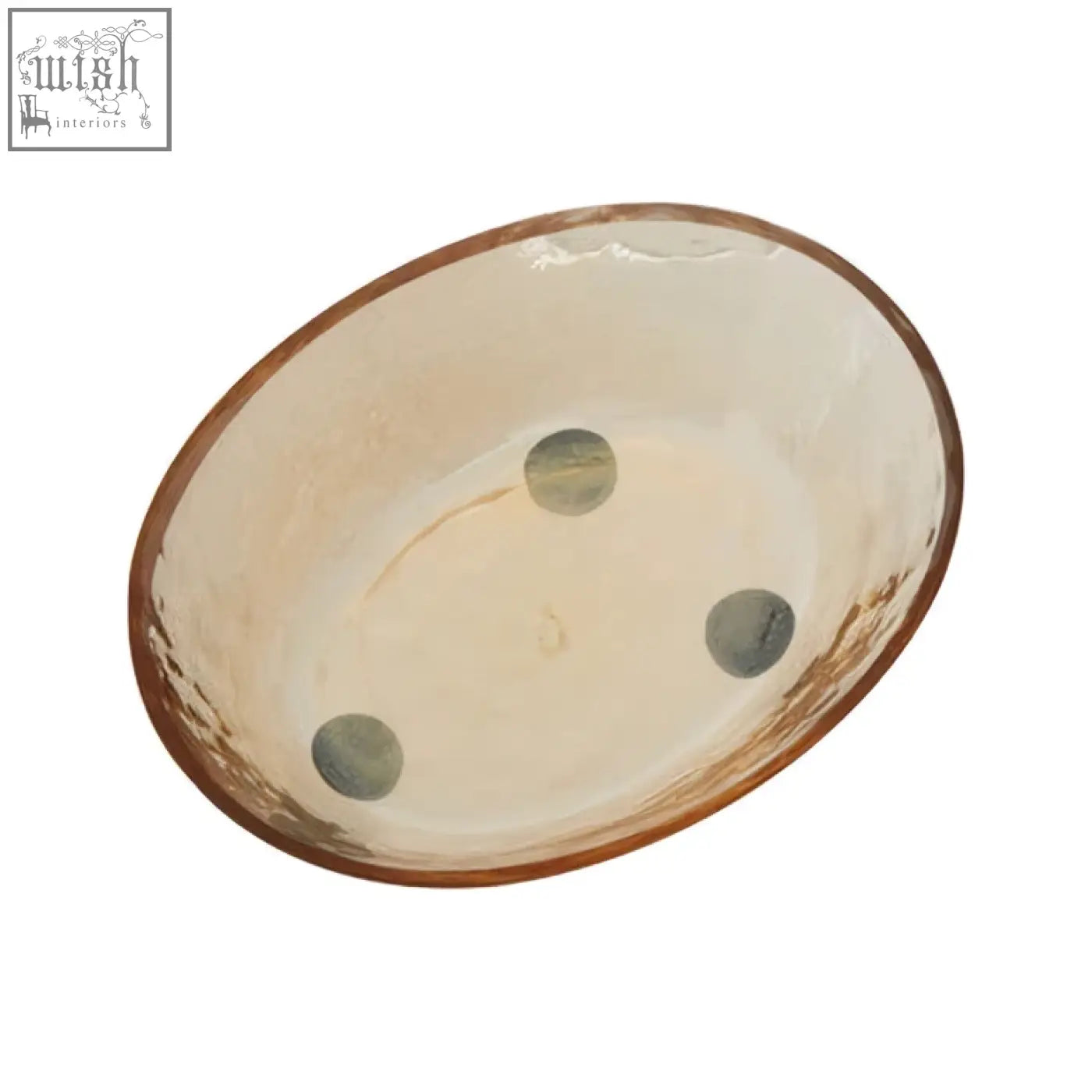 A rustic allegra glass soap dish with a hammered copper rim and green accents on a cream ceramic bowl interior