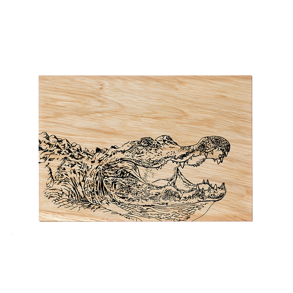 A rectangular oak serving and cheese board with a black burned detailed alligator head illustration