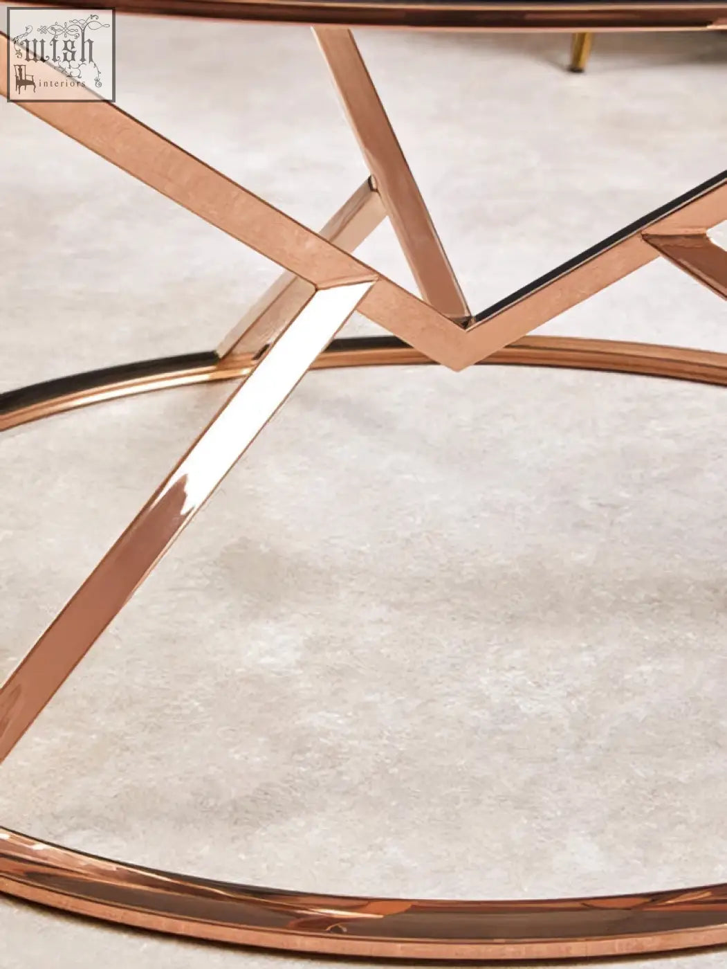 Allure corseted round rose gold coffee table with geometric metal frame and sleek rose gold finish