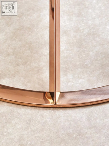 Minimalist rose gold coffee table with a sleek corseted round metal frame perfect for stylish living spaces