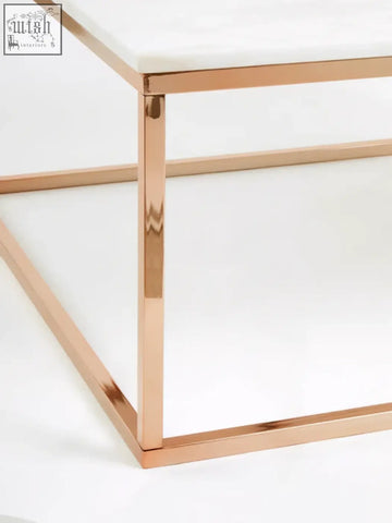 A modern square rose gold coffee table with a white marble top and sleek metal frame for stylish living rooms