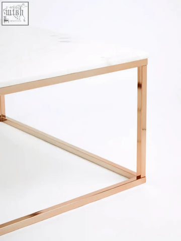 A sleek square rose gold coffee table with a white marble top perfect for modern living spaces
