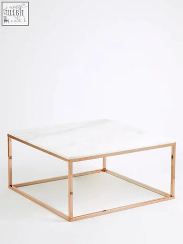 A sleek square rose gold coffee table with a white marble top perfect for modern living spaces