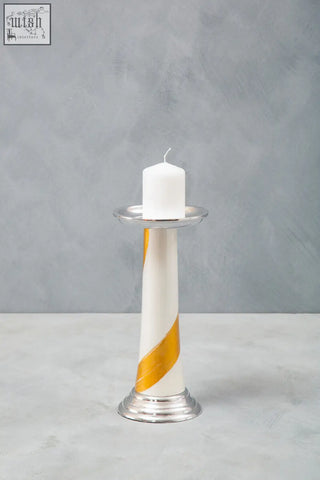 A sleek white candle with a gold stripe on a silver metal stand in the alma white and gold gold candle holder