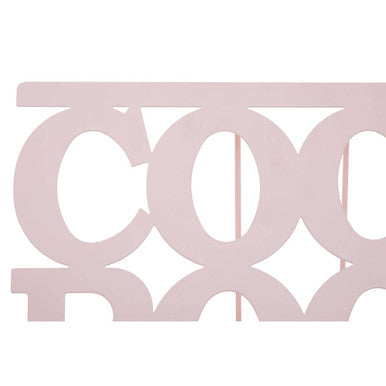 A delicate alpha pink cookbook stand with light pink metallic lettering and minimalist design in pink enamel finish