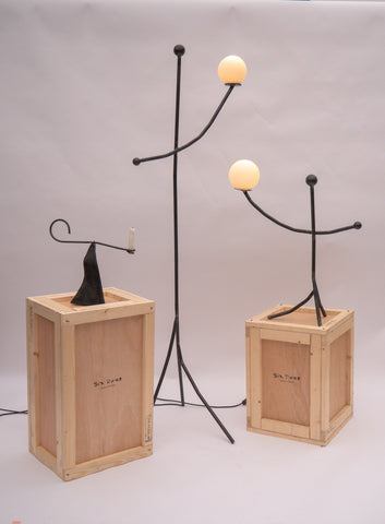Black wrought iron aluminium balancing act floor lamp with two glowing spherical bulbs for ambient lighting