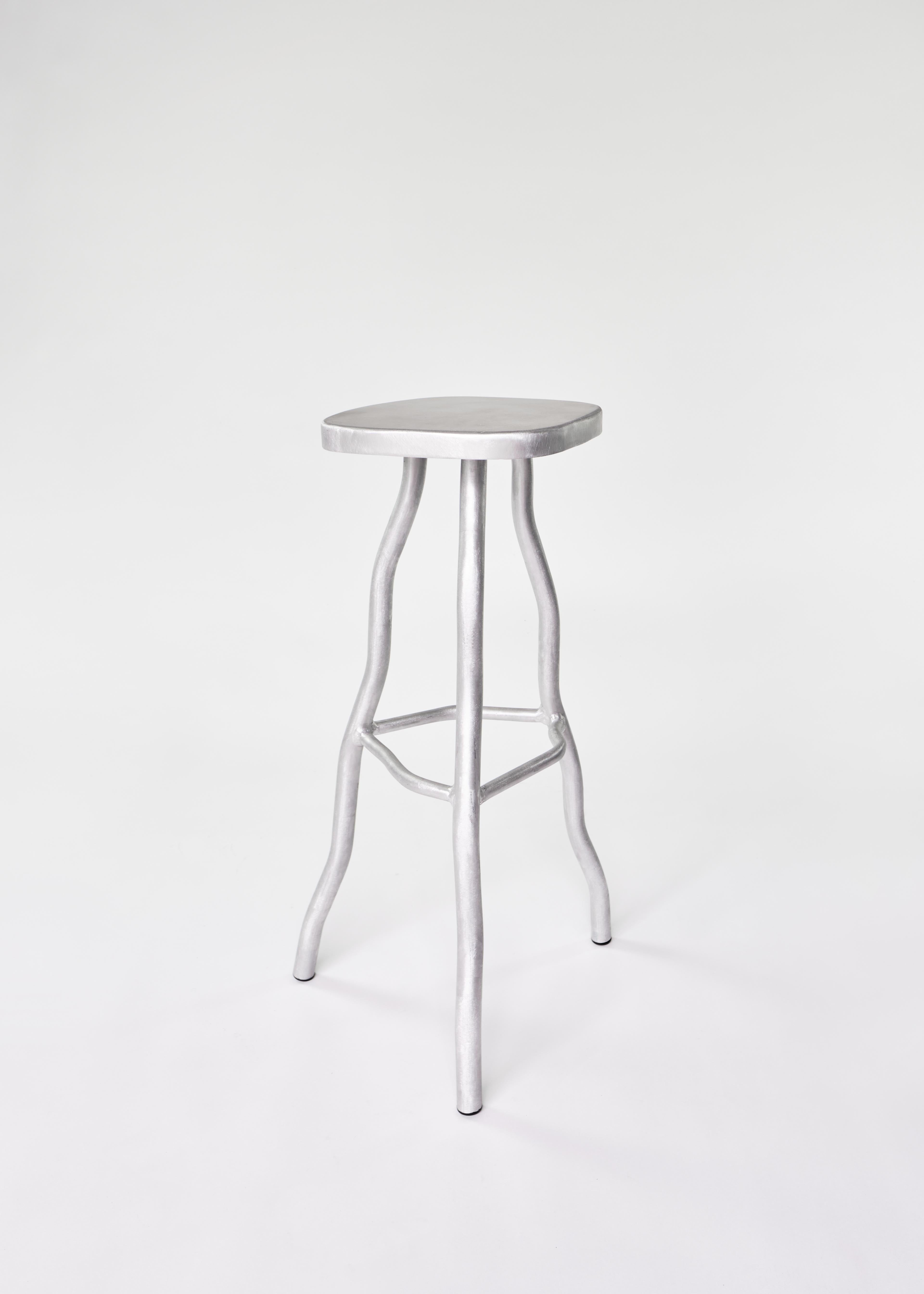 Silver metallic aluminium bar stool with smooth rounded seat and organic tree like legs for stylish seating