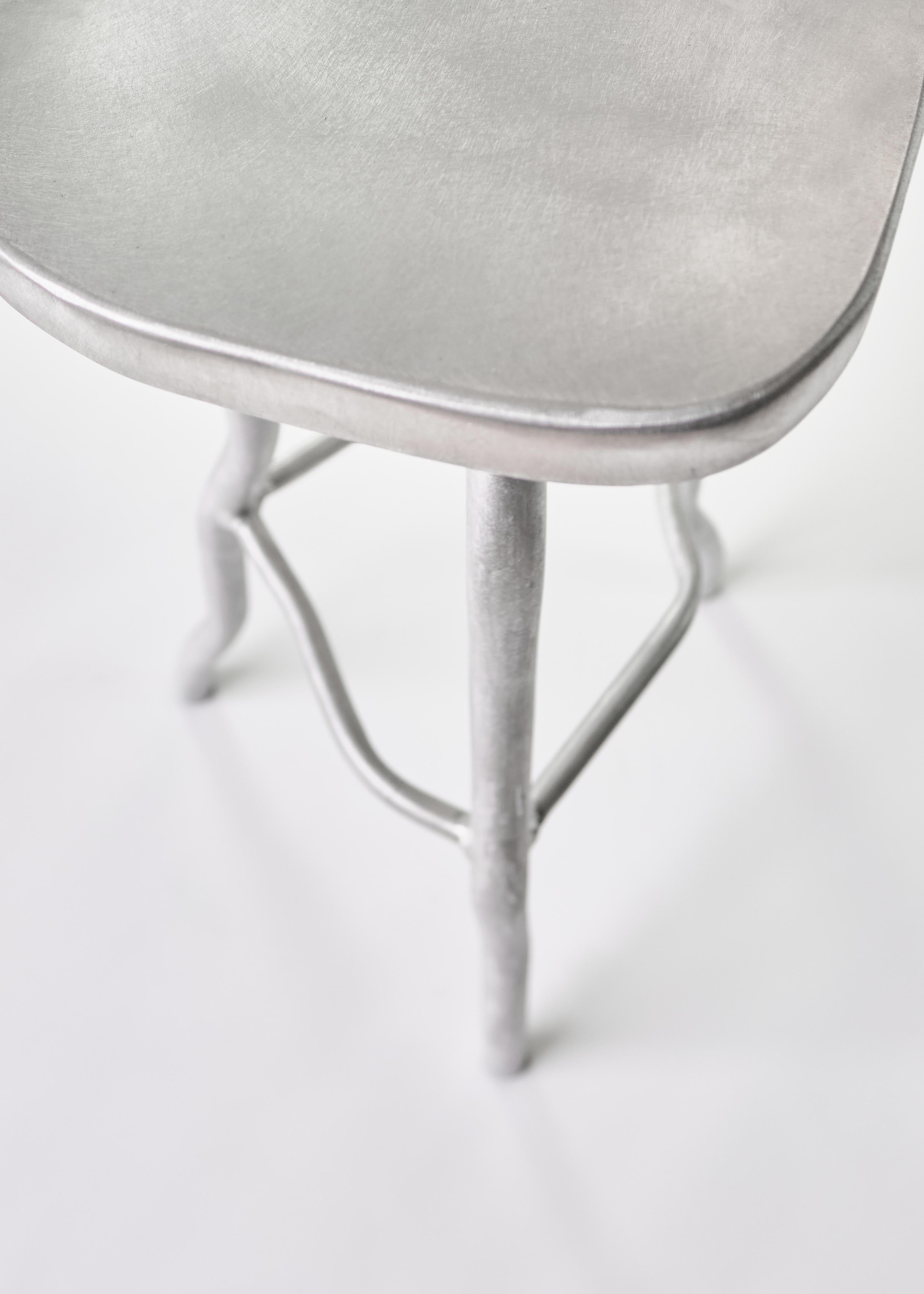 Silver metallic aluminium bar stool with smooth rounded seat and slender curved legs for stylish seating