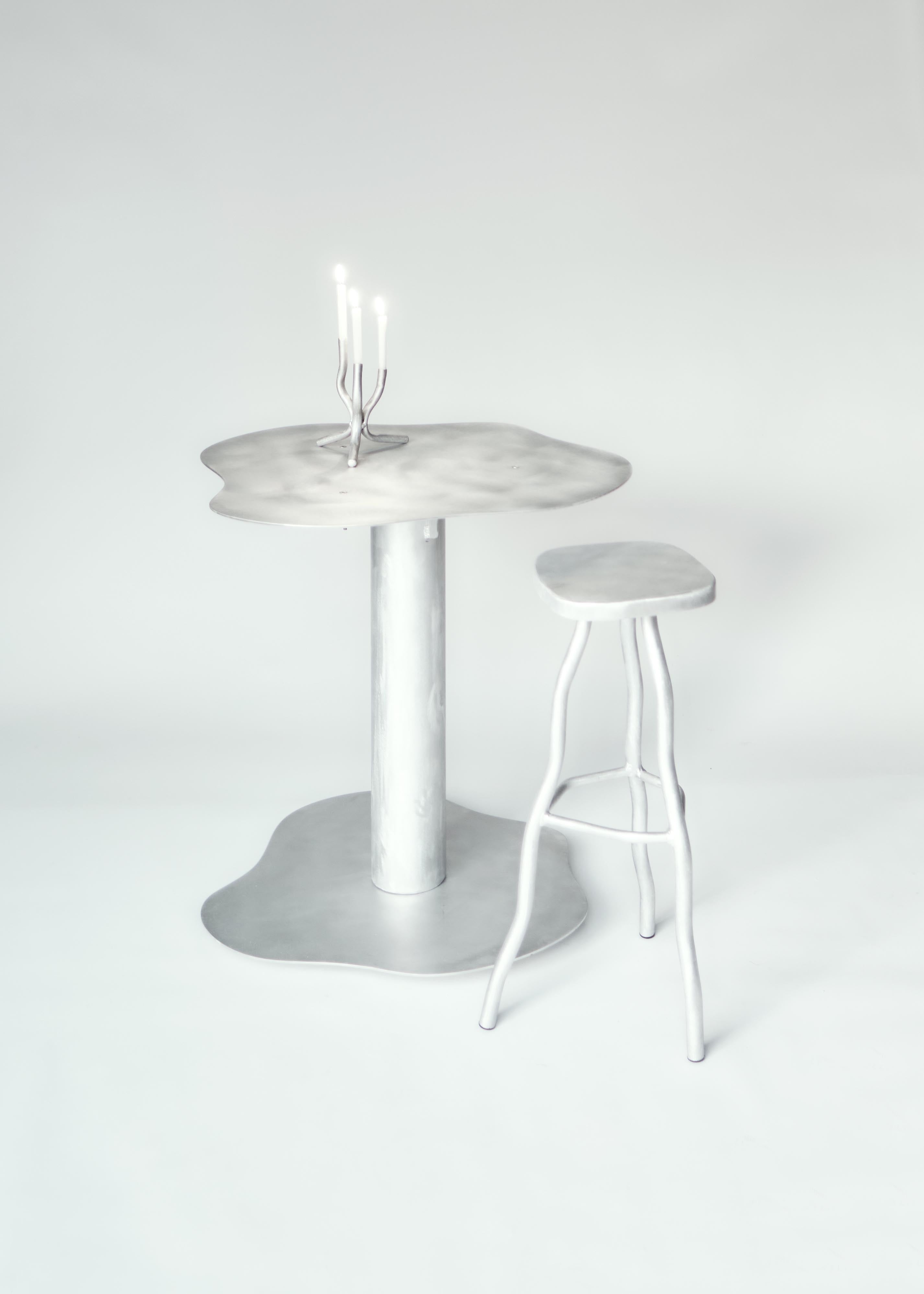 Silver metallic aluminium bar stool with a melting organic shape and matching stool for modern seating