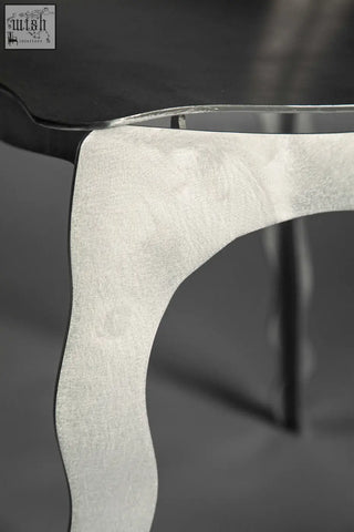 A sleek silver-toned aluminium contemporary chair leg with a smooth curved design and subtle texture