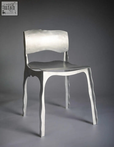 A sleek silver aluminum contemporary chair with a minimalist design and flowing organic legs