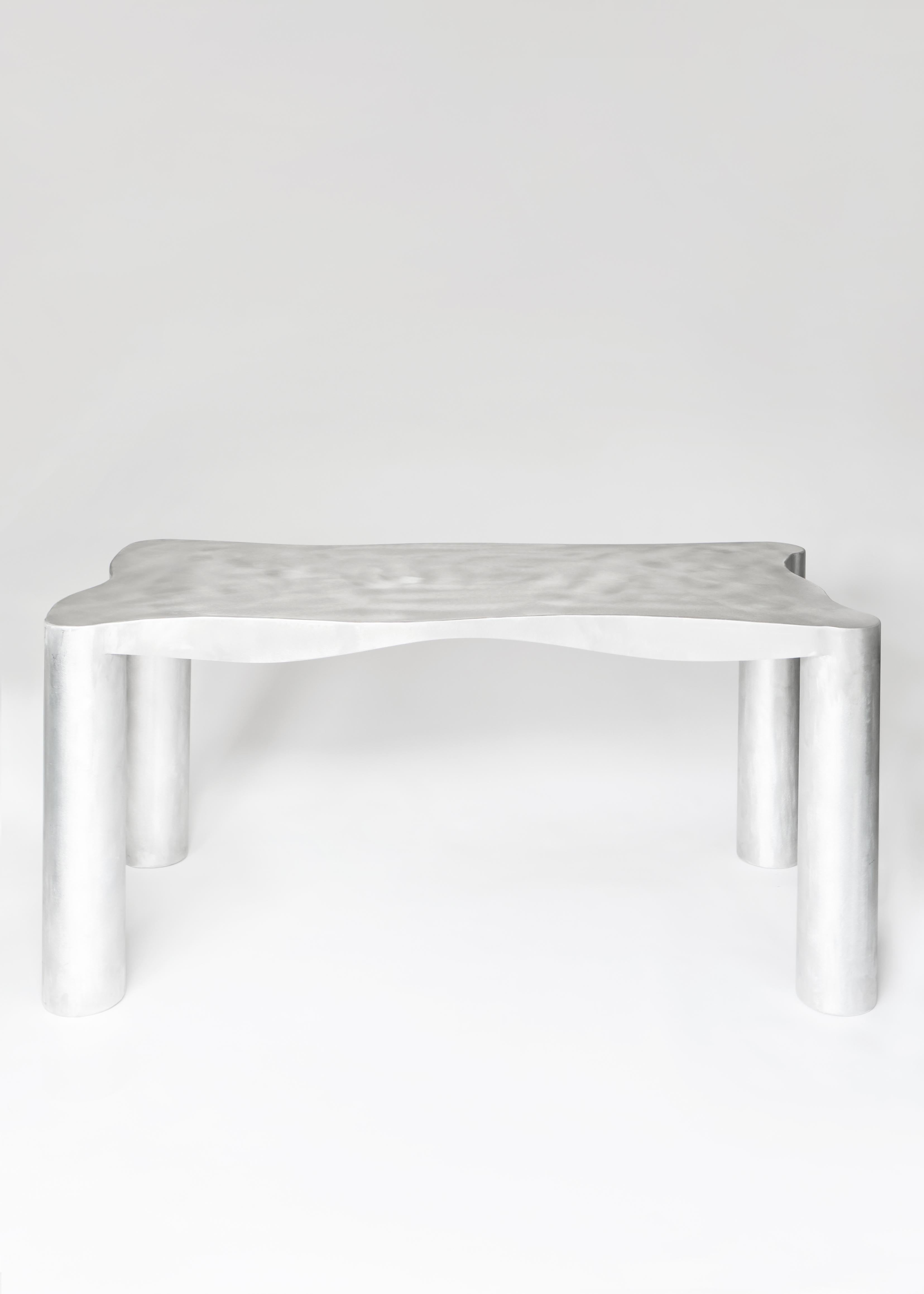 Silver metallic aluminium dining table with smooth textured top and cylindrical legs perfect for modern dining spaces