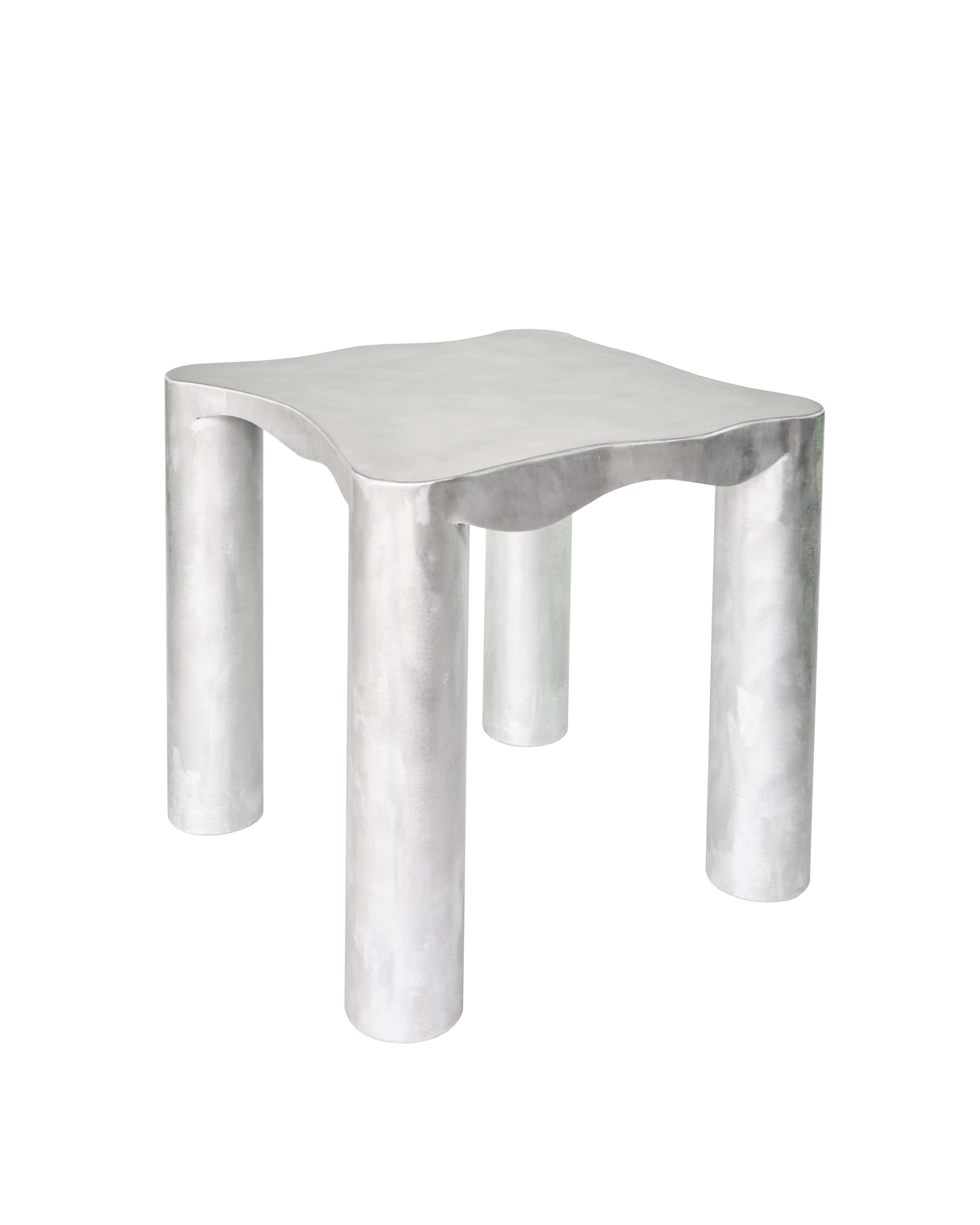 Silver metallic aluminium kitchen table with smooth wavy top and cylindrical legs for modern kitchen use