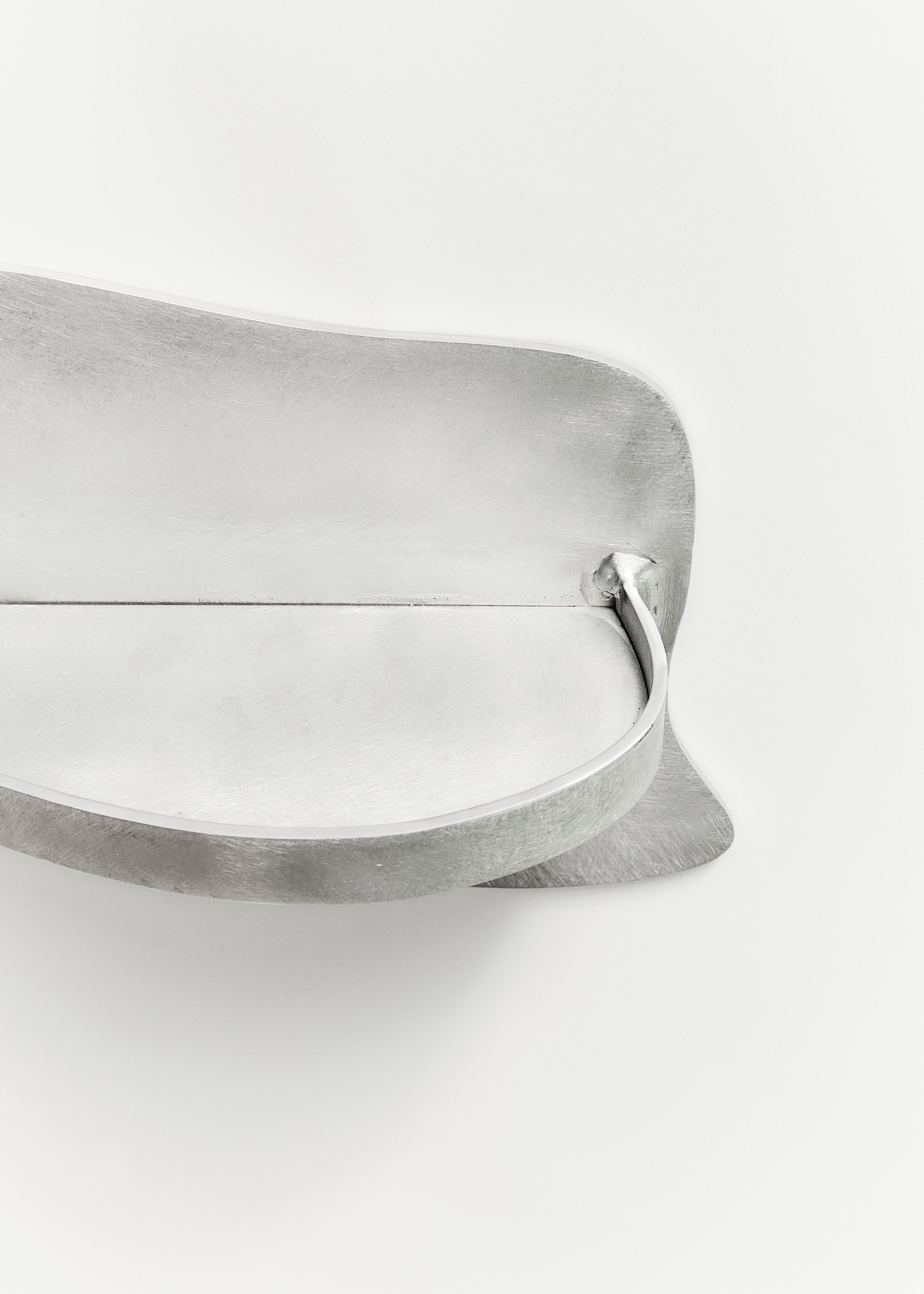Silver-toned metal belt buckle with smooth curved design and brushed finish for aluminium middle shelf accessory