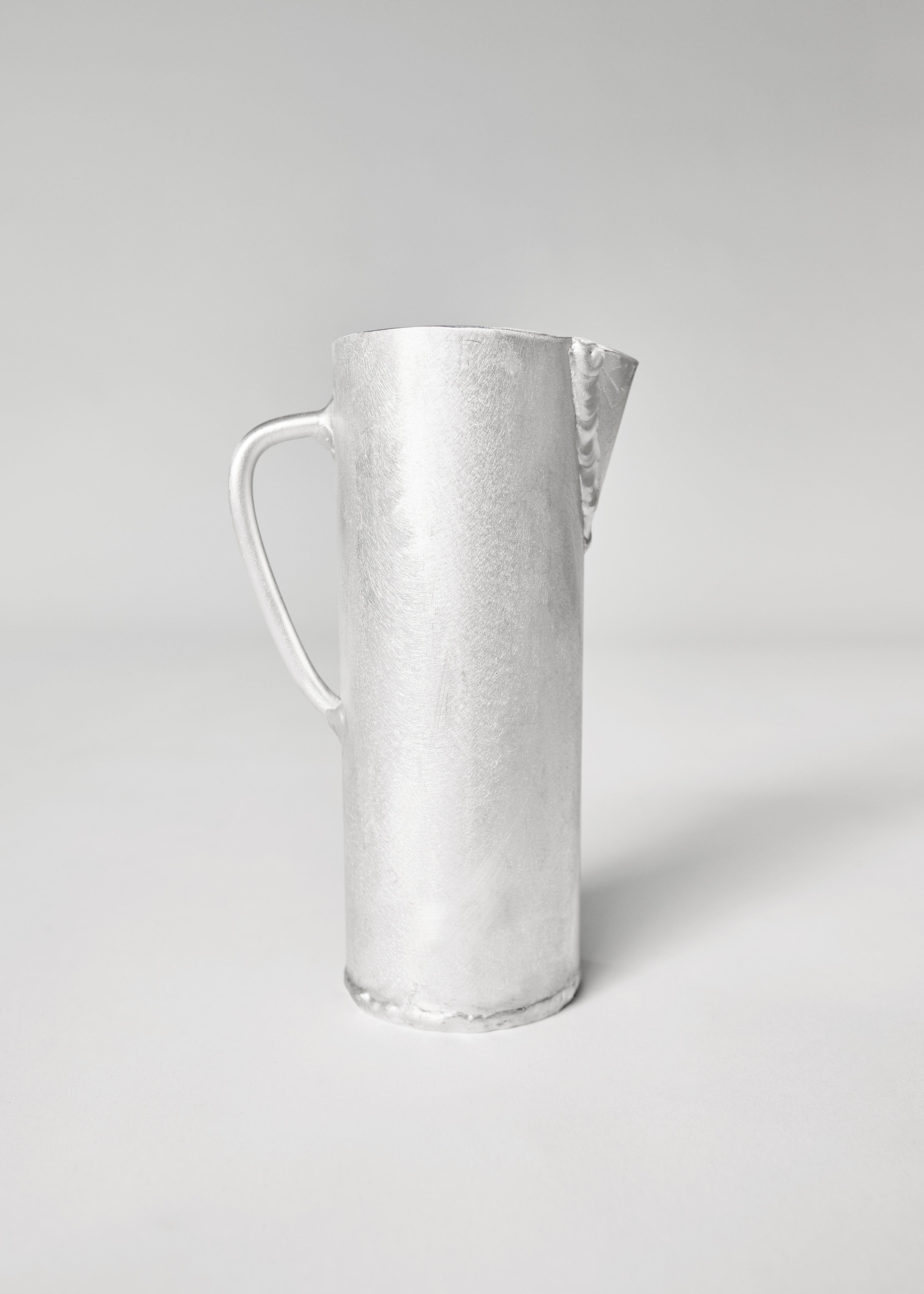 Silver-toned hammered aluminium jug with sleek handle and spout perfect for serving drinks