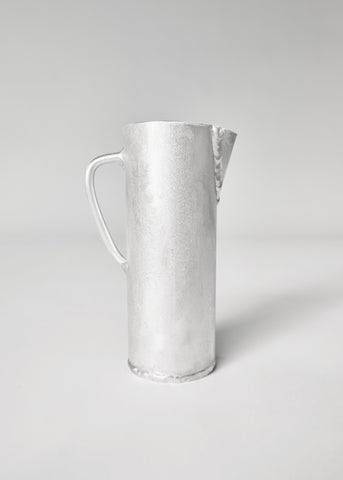 Silver-toned hammered aluminium jug with sleek handle and spout perfect for serving drinks