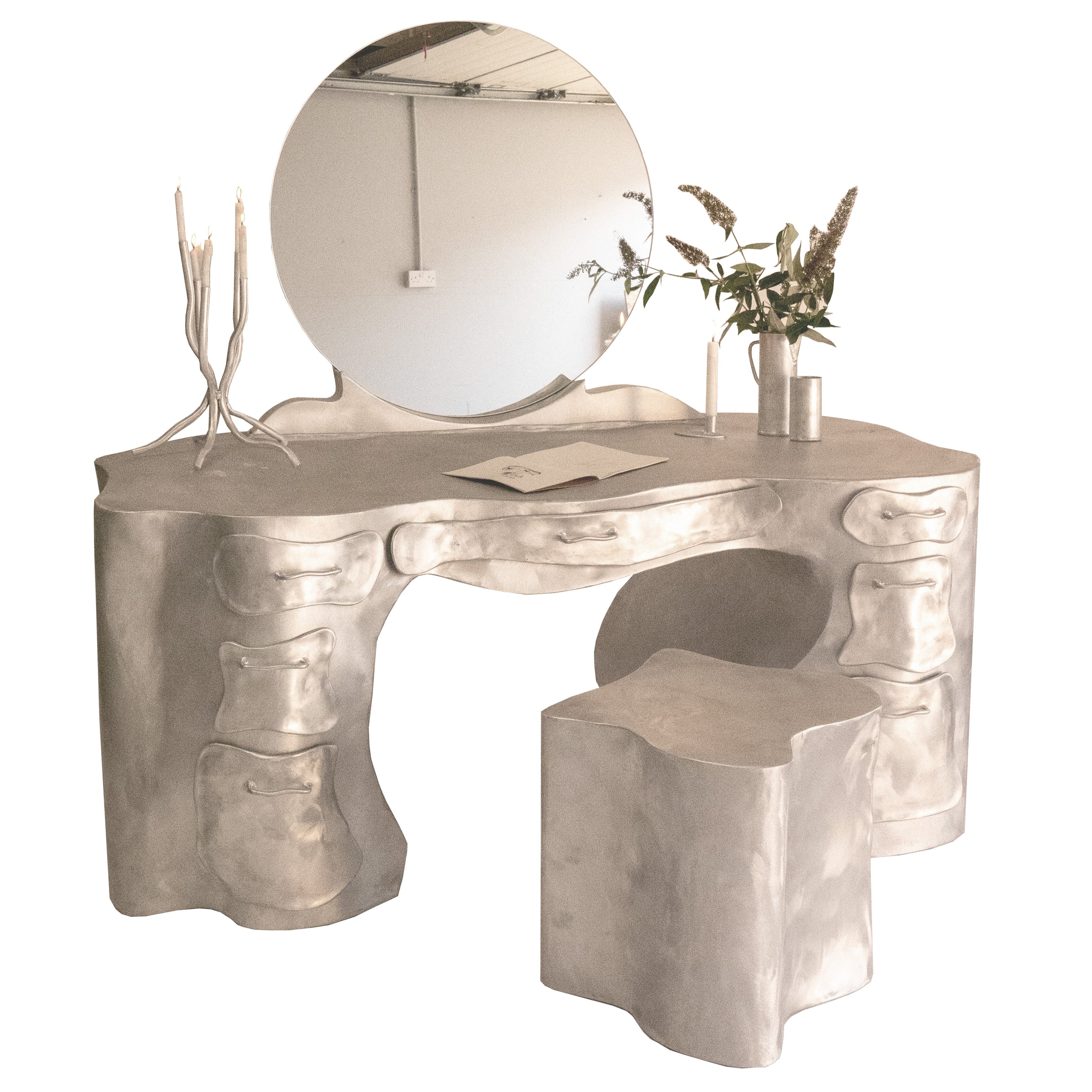 Silver aluminium vanity desk with bone-like sculpted texture and integrated mirror for stylish grooming