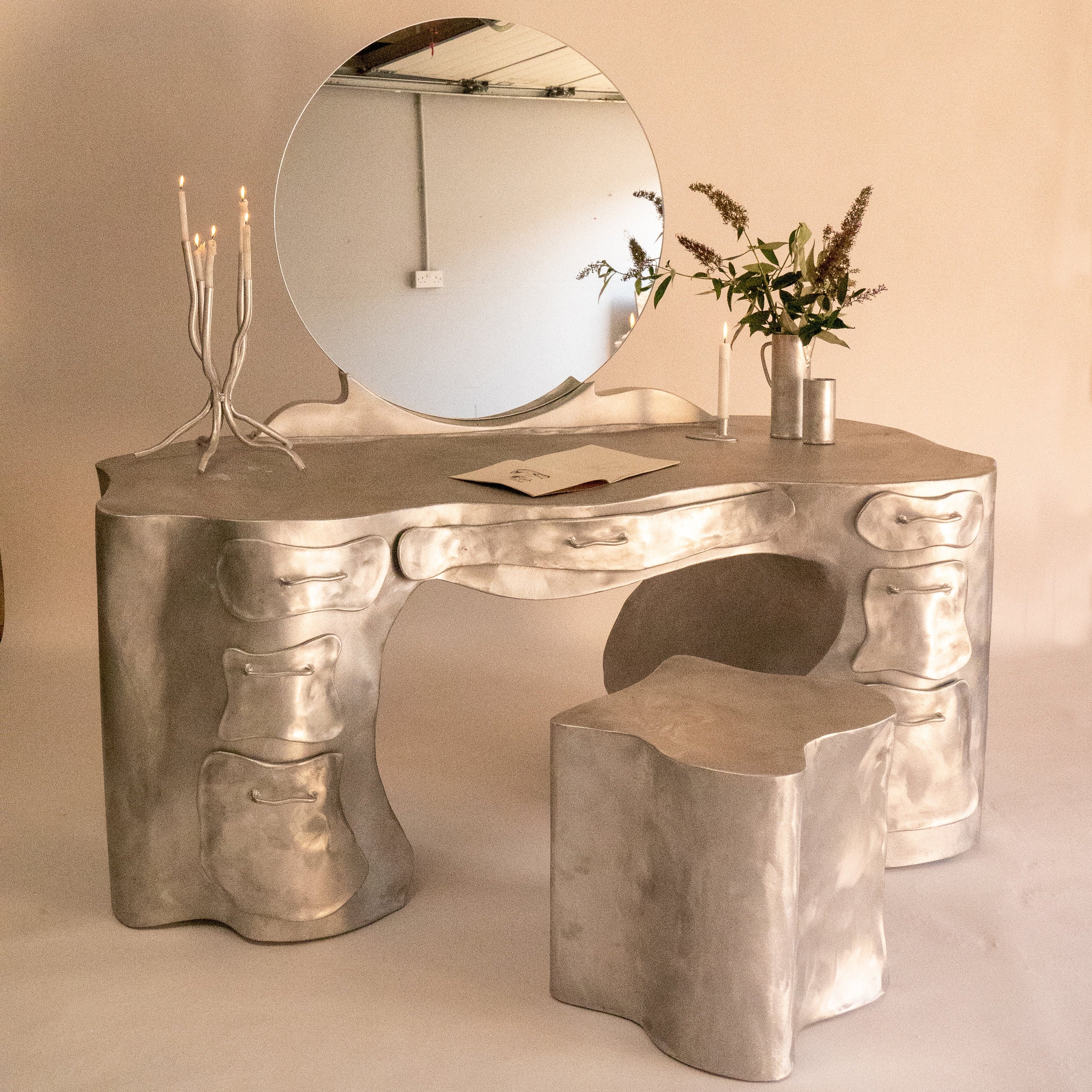 Silver aluminium vanity desk with sculpted organic bone-like contours and multiple storage drawers for makeup and grooming