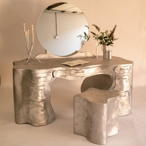 Silver aluminium vanity desk with sculpted organic bone-like contours and multiple storage drawers for makeup and grooming