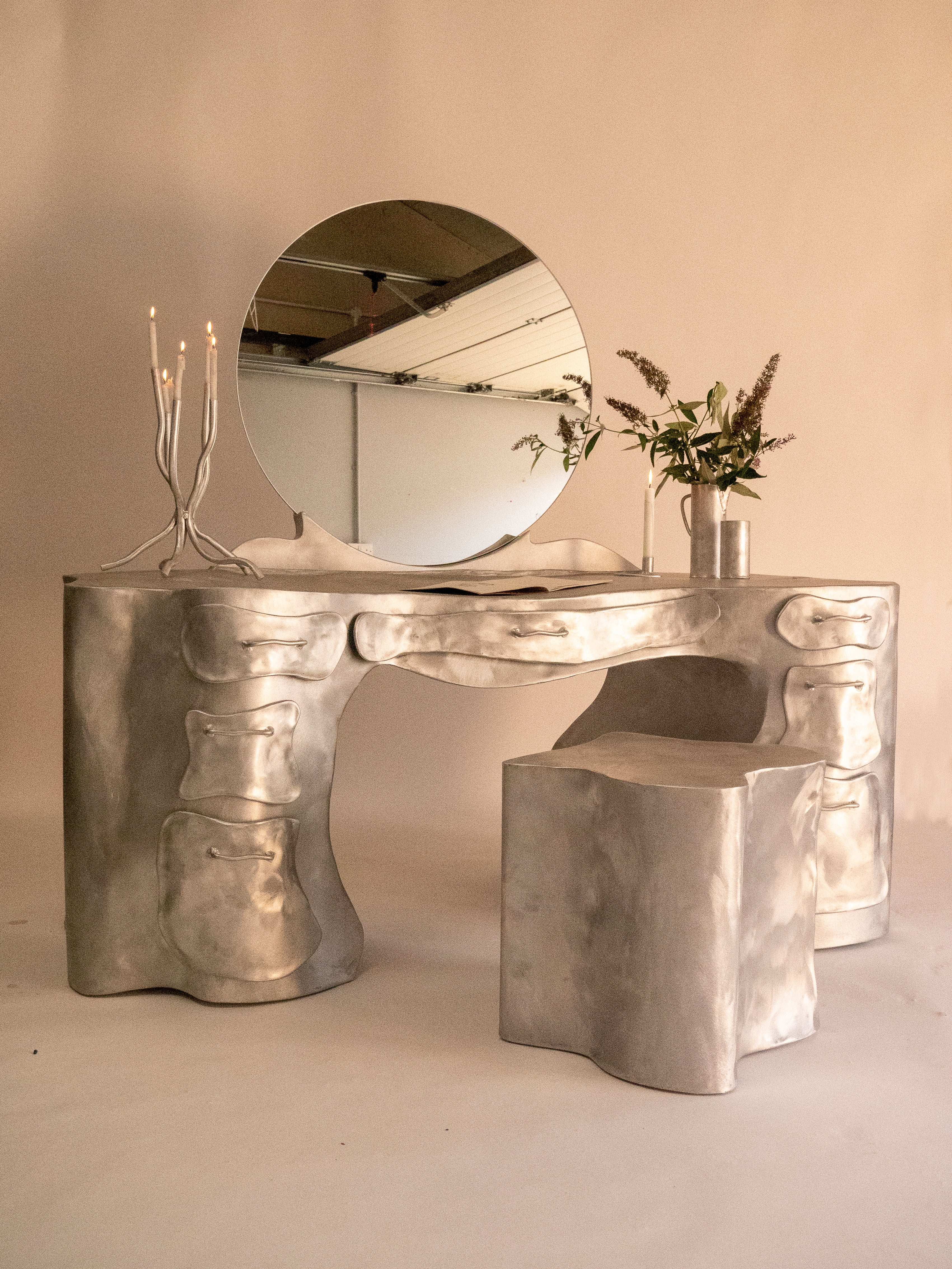 Silver aluminium vanity desk with organic bone like contours and matching stool for stylish makeup setup