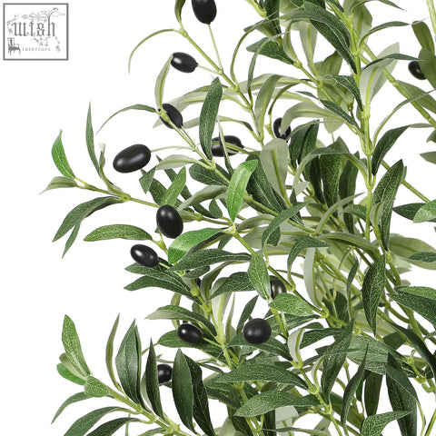 Artificial olive tree with glossy black olives and detailed green leaves in white pot with natural wood trunk