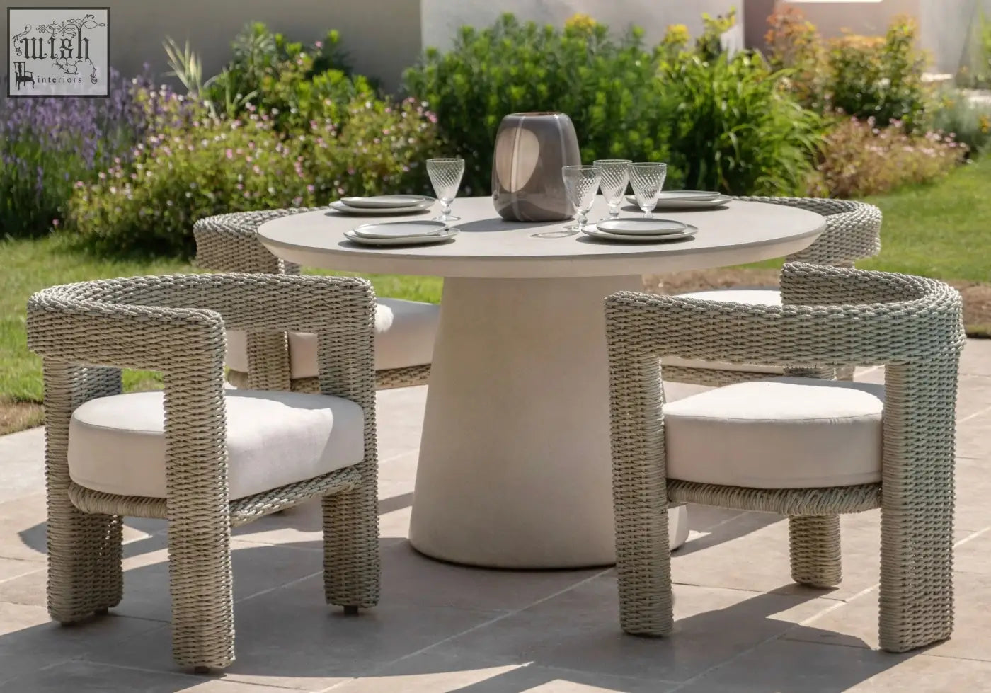 Modern outdoor dining set with woven wicker alva chairs in white cushions and round concrete table with steel frame