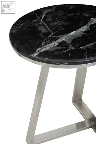 Alvaro round side table with black marble top and silver sledge base featuring sleek polished stainless steel legs