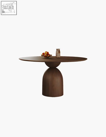 A sleek dark brown solid wood dining table with a rounded top and sculptural base amaia round pedestal dining table