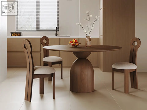 Amaia round pedestal dining table in solid wood with a sculptural base and minimalist design in black finish
