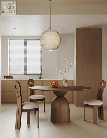 Amaia round pedestal dining table in solid wood with black finish and matching curved backrest chairs with upholstered seats