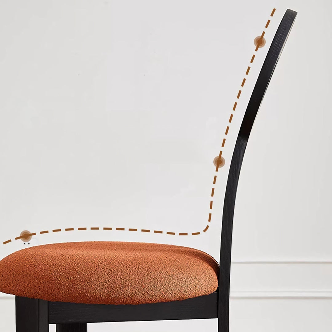 Amaris dining chair with black wood frame and textured orange boucle upholstered seat perfect for dining areas