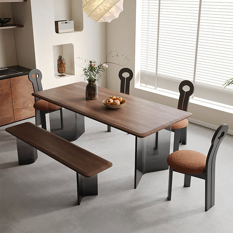 Modern wooden dining table with sleek black metal legs and warm brown finish paired with amaris dining chair boucle