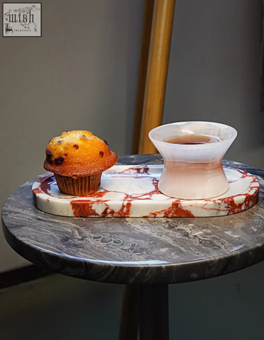 A golden brown chocolate chip muffin on a white and red amaryllis marble tray perfect for serving and consider shipping cost or offer financing