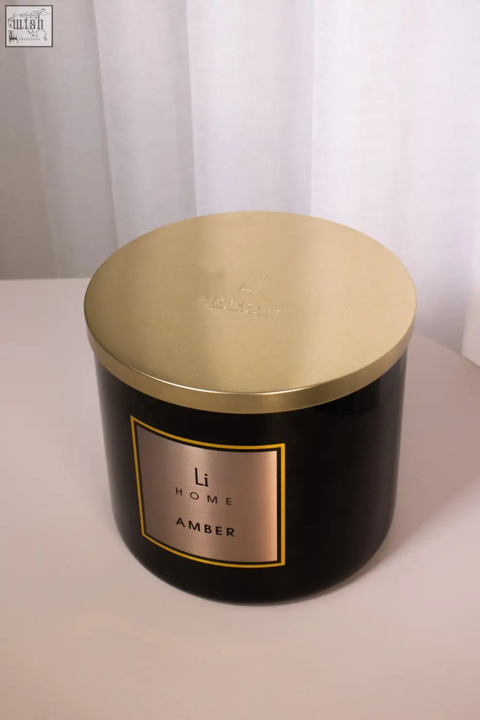 Black cylindrical large candle with gold lid and label from li home amber scent 3 wick luxury candle 1kg collection