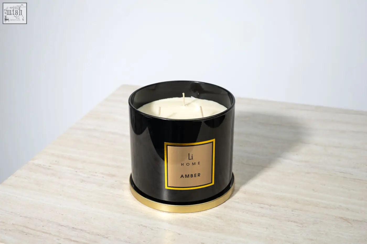Black cylindrical amber 3 wick luxury candle with gold trim from li home perfect for large candle collection