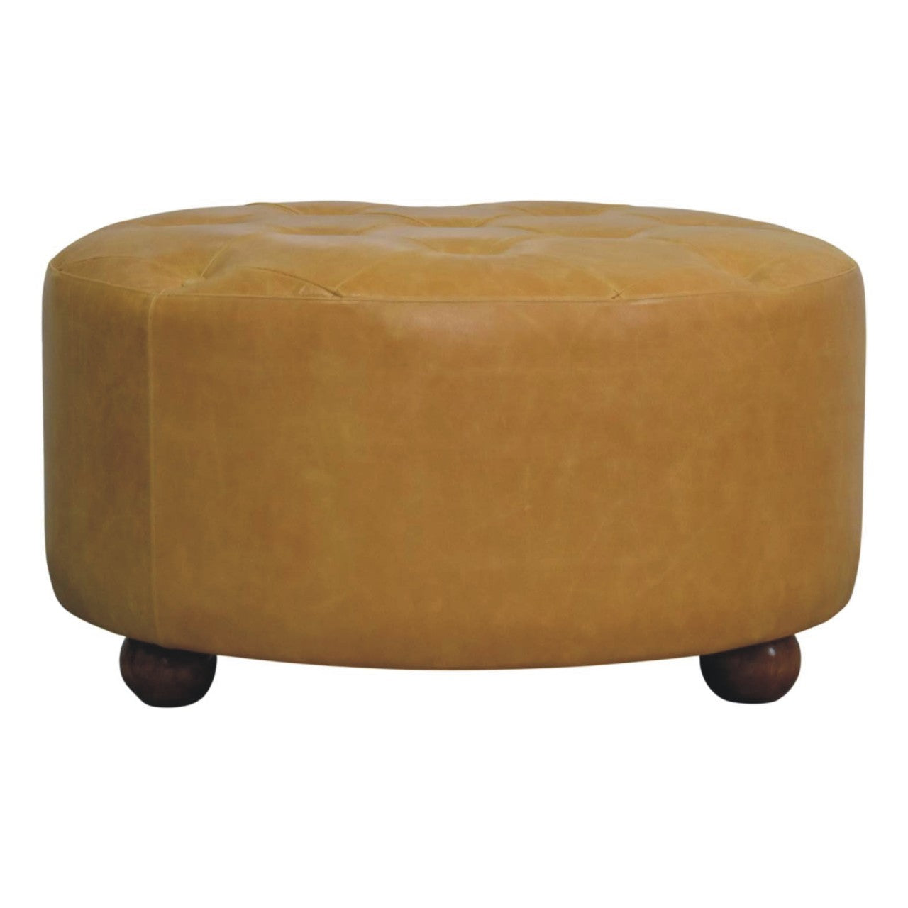 Tan leather tufted ottoman with dark wooden ball feet styled as an amber oak leather coffee table centerpiece