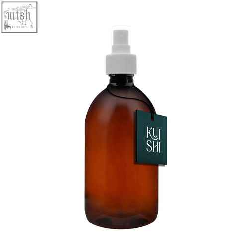 A sleek amber plastic atomiser spray bottle with white nozzle and dark green kui shi tag