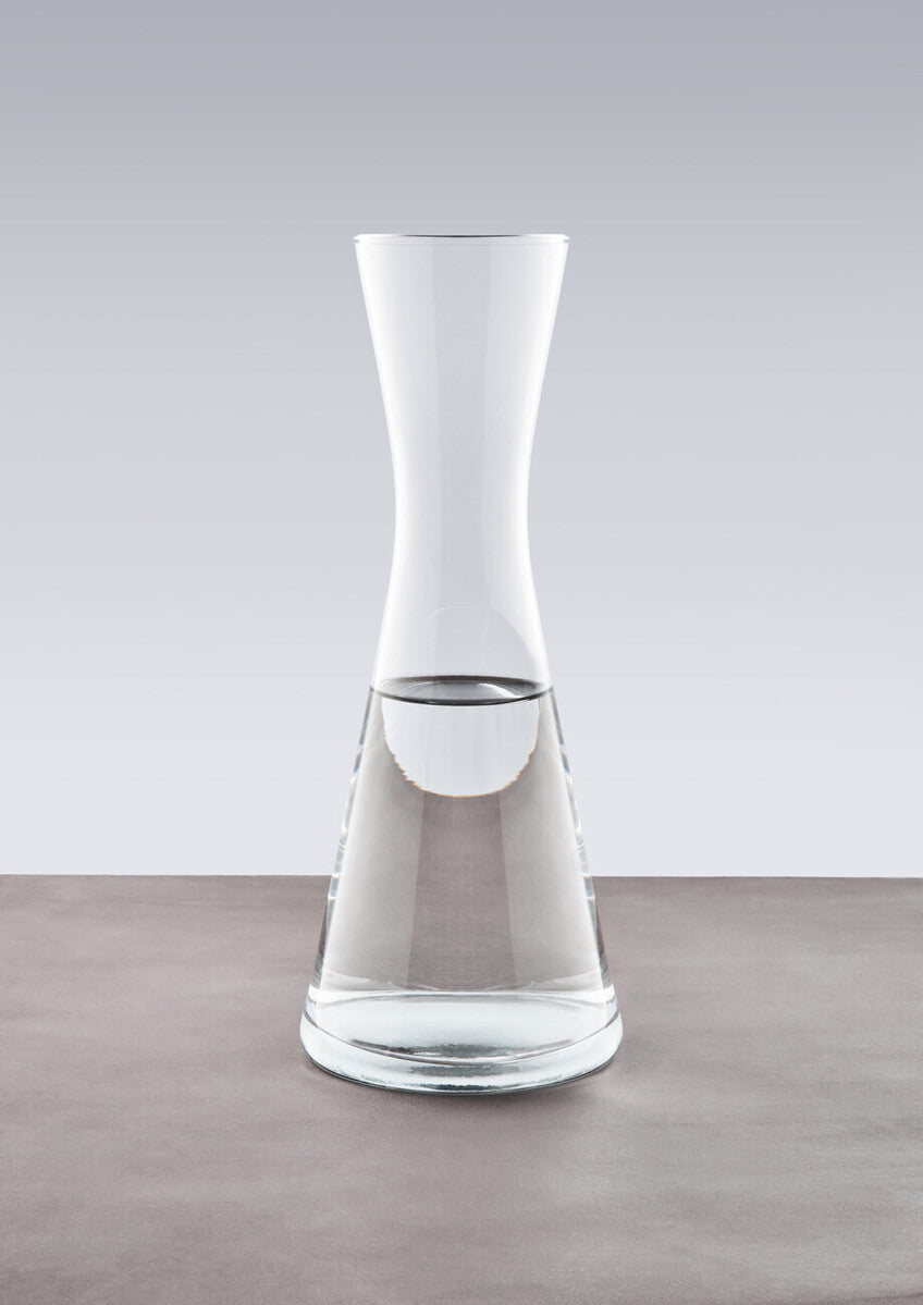 Ambra clear glass carafe with a sleek modern design featuring a wide base tapering to a narrow neck glass carafe