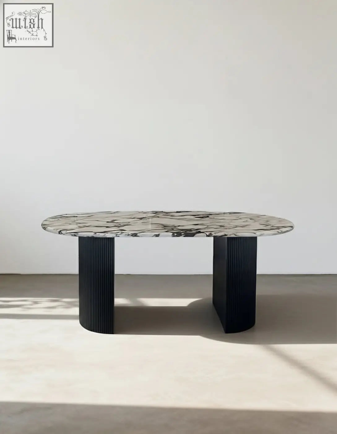 Elegant amina oval dining table with a sleek black marble top and ribbed black metal legs perfect dining table choice