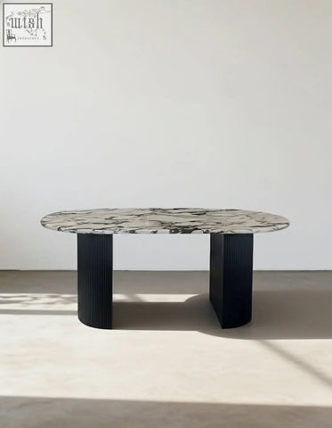 Elegant amina oval dining table with a sleek black marble top and ribbed black metal legs perfect dining table choice