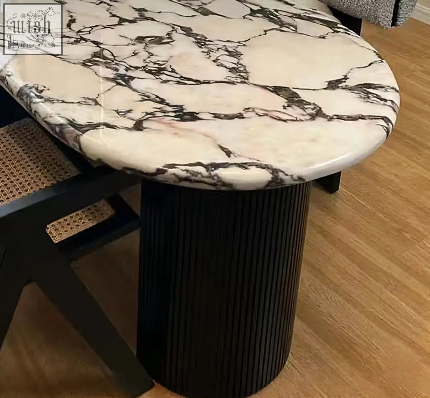 Elegant amina oval dining table with white and black marble top on a sleek ribbed black pedestal base