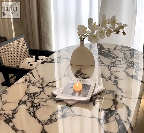 Amina oval dining table with solid wood and marble holds a cream ceramic vase with white orchids for decor